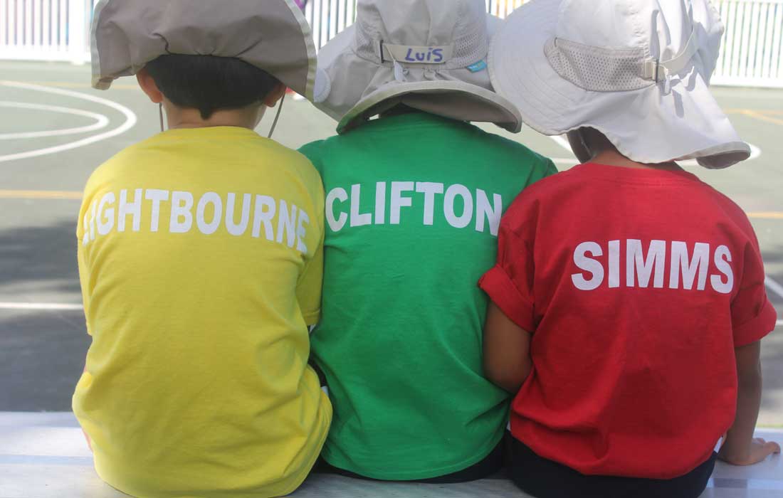 Three students in t-shirts with house names